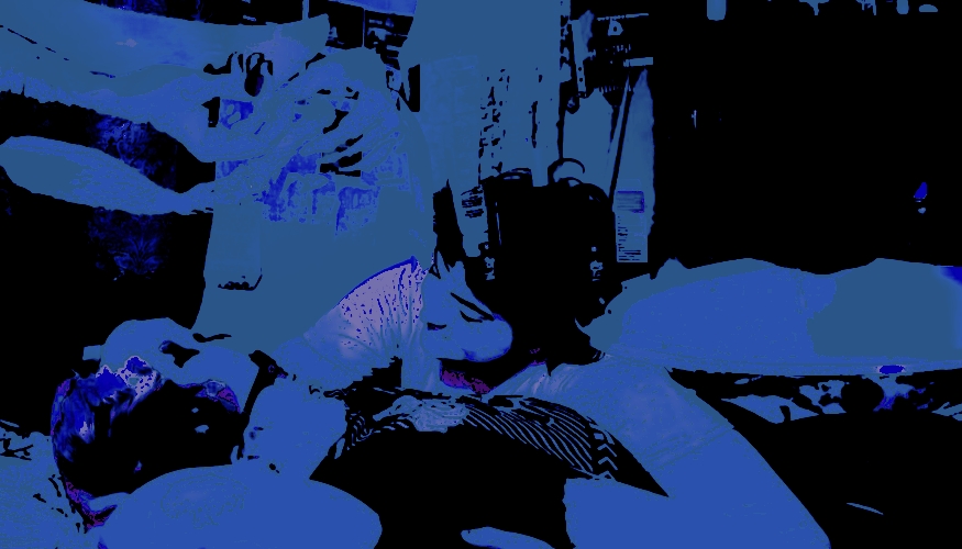 heavily edited digital photo of two people lying on top of one another, looking at each other lovingly. there's an overlay of a person doing a testoterone shot into their lower abdomen. the whole image in bright blue and black.